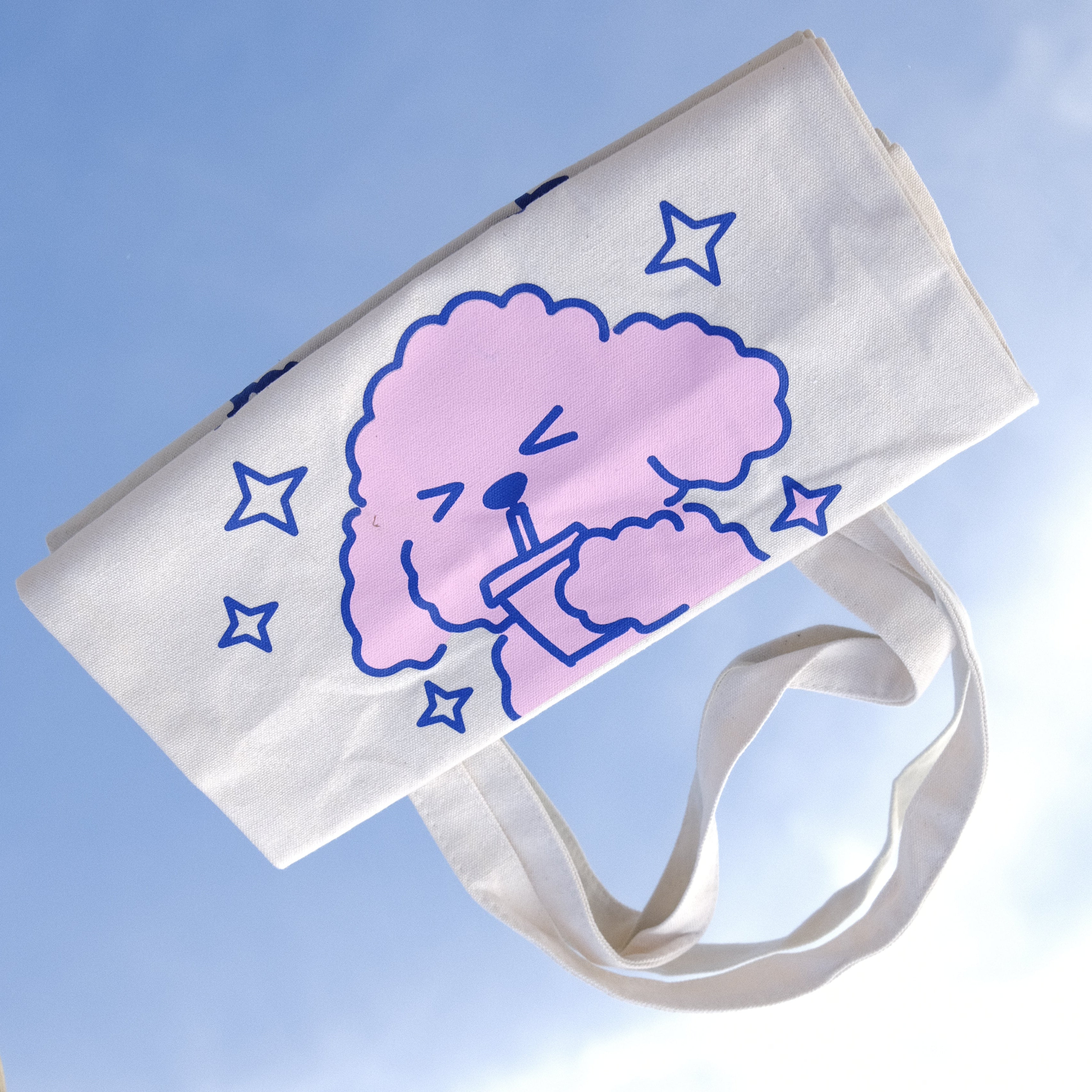 Tote bag with a brain design and stacked small bags on a textured surface