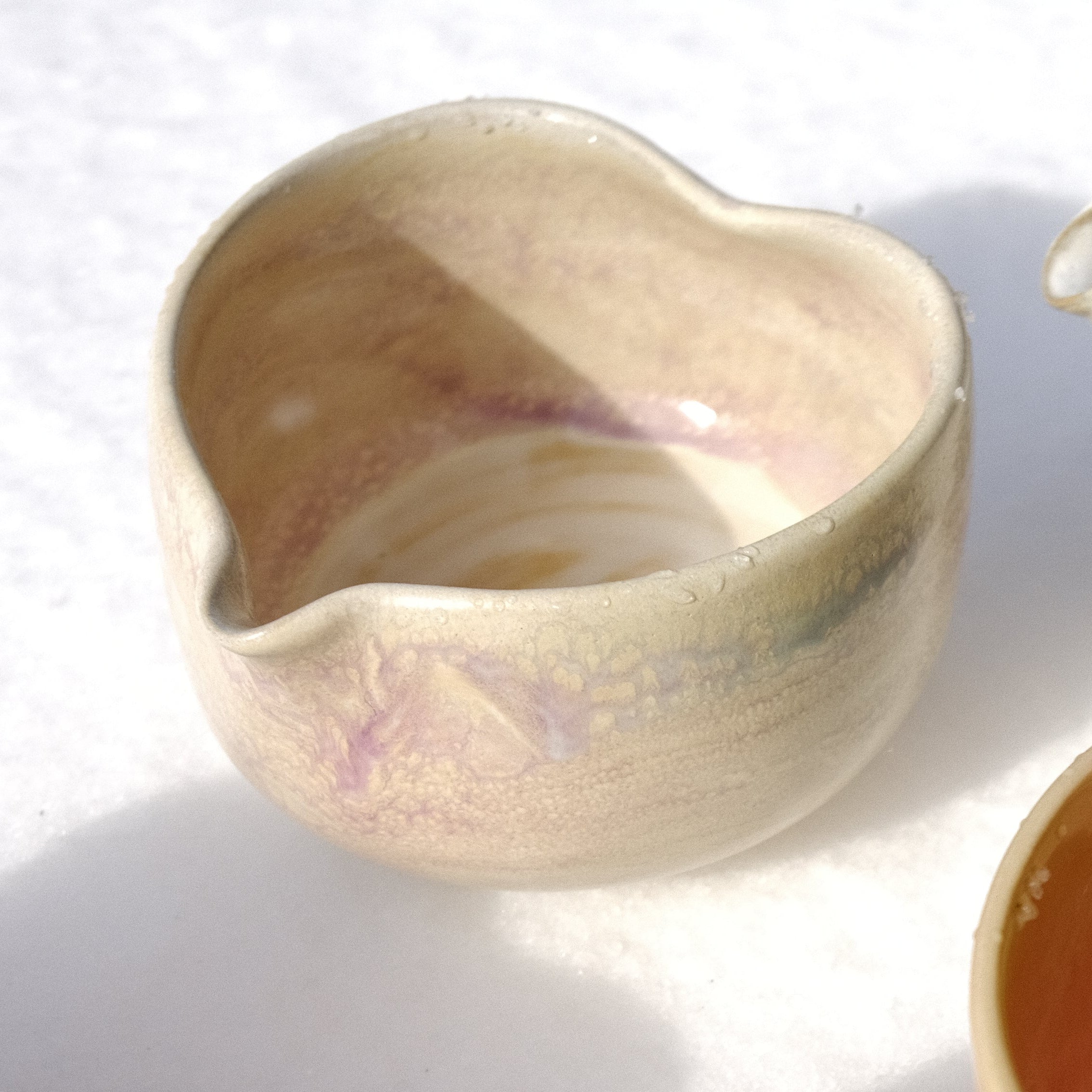 Collection of ceramic bowls and vases on a white surface